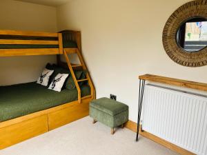 a bedroom with a bunk bed and a chair and a mirror at Pingle Nook Barn on the Farm - Denby Dale in Huddersfield