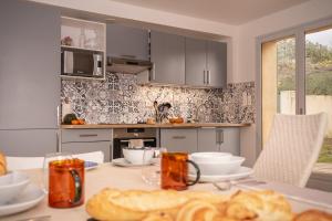 a kitchen with a table with food on it at Villa Pierre Blanche le calme a 5mn du centre ville in Nîmes +29 photos