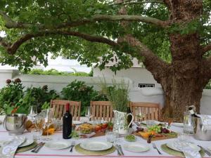 a table with food and a bottle of wine at Navarre Residence in Stellenbosch