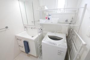 a white bathroom with a washing machine and a sink at Maison Haan Motobu in Motobu +92 photos