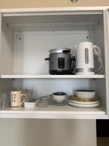 a cupboard filled with pots and pans and plates at Avida Aspira Studio, 27th Floor, Pool & Gym in Cagayan de Oro