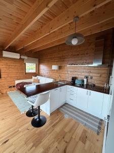a kitchen with white cabinets and a table in a room at Sunset Eco Shelter 4 in Ponta do Pargo