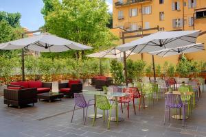 a patio with tables and chairs and umbrellas at UNA Hotels Bologna Centro in Bologna