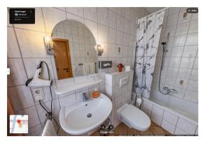 a bathroom with a sink and a tub and a toilet at Hotel Karger in Wadersloh