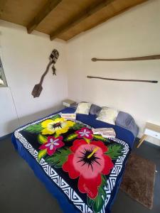 a bedroom with a bed with a floral bedspread at Studio Sunset Rapa Nui in Hanga Roa