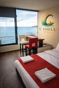 una camera d'albergo con un letto e vista sull'oceano di C Shell Hotel a Jounieh
