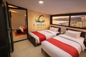 due letti in una stanza d'albergo con aria condizionata, cartello dell'hotel Shell di C Shell Hotel a Jounieh