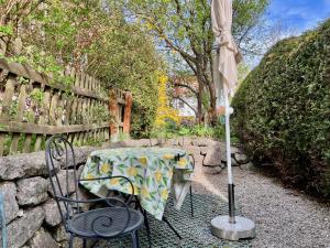 a table and chairs with an umbrella on a patio at Beim Thöny - schönes Apartment mit privatem Zugang in Utting am Ammersee