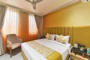 a hotel room with a bed and a chair at Bhagwati luxuria in Indore +44 photos