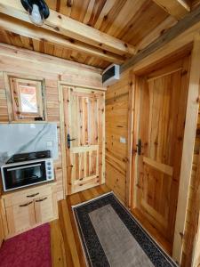 a kitchen with a stove and a microwave in a cabin at Brvnara Panda Tara in Rača