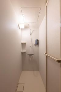 a shower room with a door and a light at Waen Tenma in Osaka