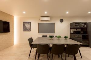 a dining room with a table and chairs and a screen at Waen Tenma in Osaka