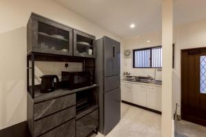 a kitchen with a black refrigerator and white cabinets at Waen Tenma in Osaka +31 photos