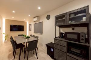 a dining room with a table and a tv at Waen Tenma in Osaka