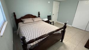 a bedroom with a wooden bed in a room at Modern 3BR Home in secure neighborhood with Free Parking & WiFi in Riverview