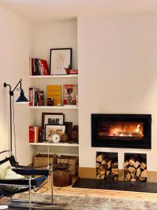 a living room with a fireplace and a chair at MAISON BO TERRA - Chambres et table d'hôtes - Massif des Écrins in Valbonnais