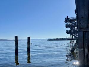 a pier with a rope sticking out of the water at Beim Thöny - schönes Apartment mit privatem Zugang in Utting am Ammersee +2 photos