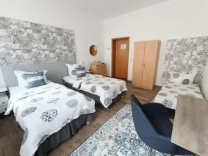 ein Schlafzimmer mit zwei Betten und einem blauen Stuhl in der Unterkunft MonAppart in Gera