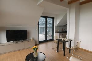 a living room with a television and a table at VILLA nad JEZIOREM in Mucharz