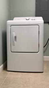 a white refrigerator sitting on the floor in a room at Modern 3BR Home in secure neighborhood with Free Parking & WiFi in Riverview