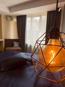 a hexagonal light fixture hanging over a bed at Family Hotel EDI in Sofia