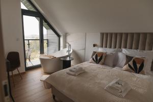 a bedroom with a large bed with a tub and a window at VILLA nad JEZIOREM in Mucharz +123 photos