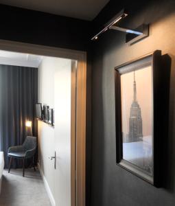 a room with a mirror and a room with a city at Hôtel Londres et New York - Teritoria in Paris
