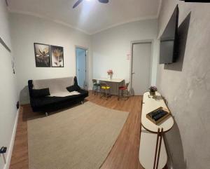 a living room with a couch and a table at Dias Felizes - Apto Centro Serra Negra - Edifício Cisne in Serra Negra