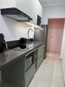 a kitchen with a sink and a stove at Dias Felizes - Apto Centro Serra Negra - Edifício Cisne in Serra Negra +11 photos