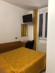 a hotel room with a bed and a flat screen tv at Hotel Mignon in Milan