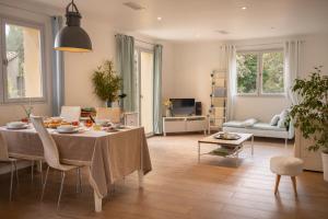 a living room with a table and a couch at Villa Pierre Blanche le calme a 5mn du centre ville in Nîmes