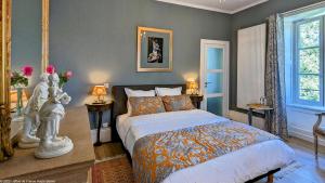 a bedroom with a bed and two tables and two windows at La Closerie des Anges in Saulx-de-Vesoul