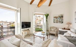 a living room with white furniture and a large window at Duplex ForVille in Cannes