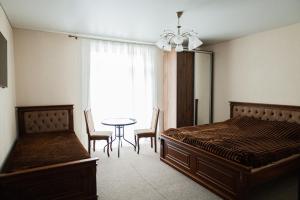 a bedroom with a bed and a table and chairs at готель-ресторан Дубок in Kvasy