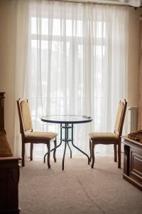a table and two chairs in front of a window at готель-ресторан Дубок in Kvasy