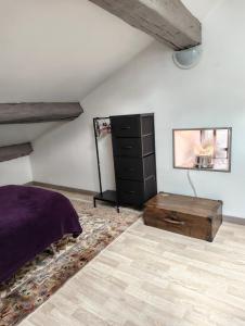 a bedroom with a bed and a dresser at Le Nid Daudèce in Le Châtelet-sur-Sormonne