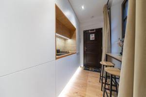 a hallway with a kitchen and a bar with stools at Apartmán Daniel in Levoča +12 photos