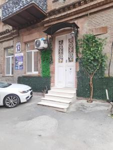a house with a white door and a car parked outside at Hidden Rooms Freedom Square in Tbilisi City
