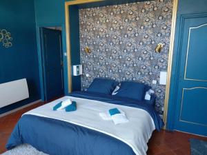 a blue bedroom with a large bed with blue pillows at La Résolue chambres d'hôtes in Millas