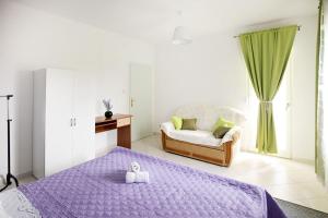 a bedroom with a purple bed and a chair at House Kuca Carevina in Krušvar +22 photos