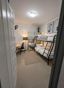 a room with three bunk beds and a desk at La Residencia Homestay in Digos