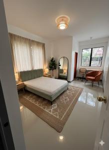 a bedroom with a bed and a living room at La Residencia Homestay in Digos