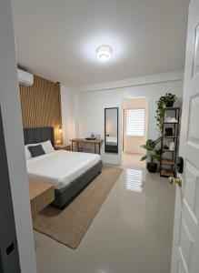 a bedroom with a bed and a table with a desk at La Residencia Homestay in Digos