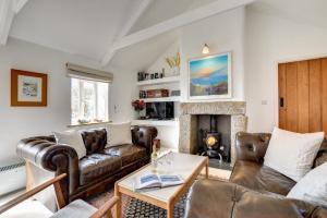 a living room with leather couches and a fireplace at 3 Bed in Sennen oc-thbyre in Sennen