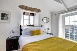 a bedroom with a large bed with a yellow blanket at 3 Bed in Sennen oc-thbyre in Sennen
