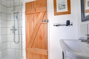 a bathroom with a wooden door next to a sink at 3 Bed in Sennen oc-thbyre in Sennen +11 photos