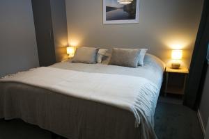 a bedroom with a large bed with two lamps at Villa Rantakukka Koli, oma ranta in Kolinkylä