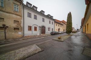 an empty street with buildings and a car parked on the road at Apartmán Daniel in Levoča