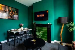 a green living room with a table and chairs at Spacious Central Nottingham House in Nottingham