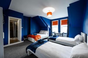 a blue room with three beds in it at Spacious Central Nottingham House in Nottingham
